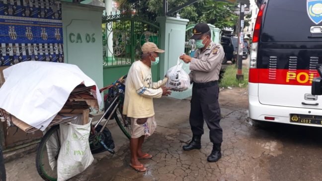Anggota Polda Sumsel Bagikan Sembako di Tengah Rintik Hujan