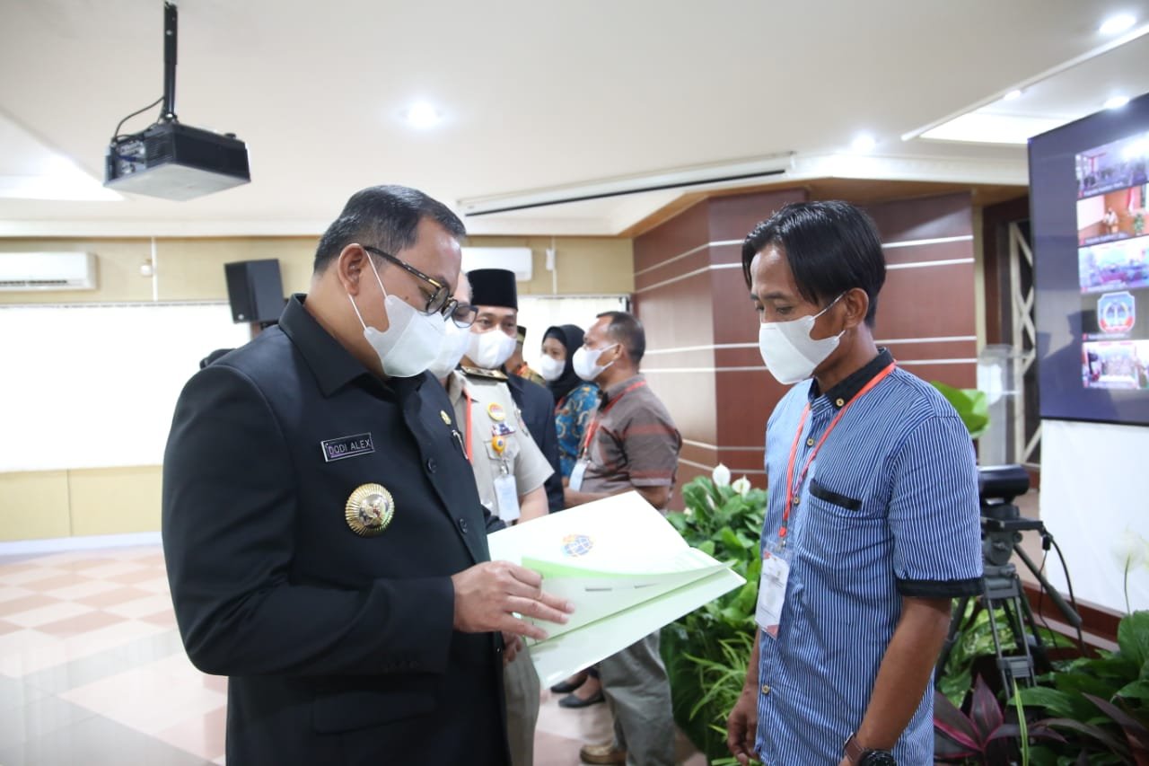Bupati Muba Dodi Reza Alex Noerdin menyerahkan Sertifikat Hak Milik (SHM) ke warganya (Dok. Humas Pemkab Muba / Mattanews.co)