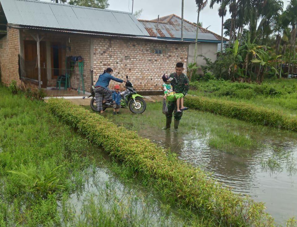 Personil Satgas TMMD, Gendong Anak yang Kesulitan Menyeberang Karena Banjir