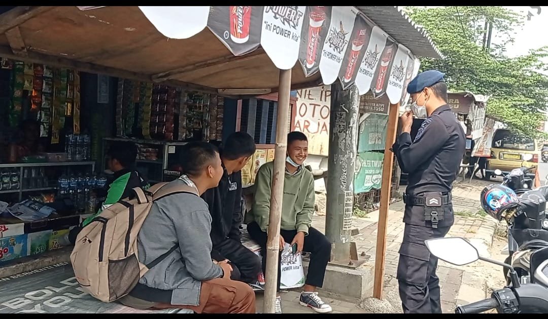 Anggota Kompi 3 Batalyon C Pelopor Satuan Brimob Polda Jabar Briptu Rengga melaksanakan kegiatan memberikan himbauan kamtibmas kepada pelajar yang masih berseragam sekolah saat nongkrong di warung kopi yang berada di wilayah jalan raya Klari Kabupaten Karawang pada Senin, (08/03/2021).