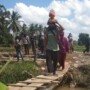 Farhan dan Anaknya saat Melintasi Jembatan Penghubung di Lokasi TMMD Kodim Palembang