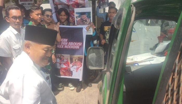 Massa dari Pemuda dan Masyarakat Sumsel Bentangkan Spanduk Berikan Dukungan Moril kepada Alex Noerdin